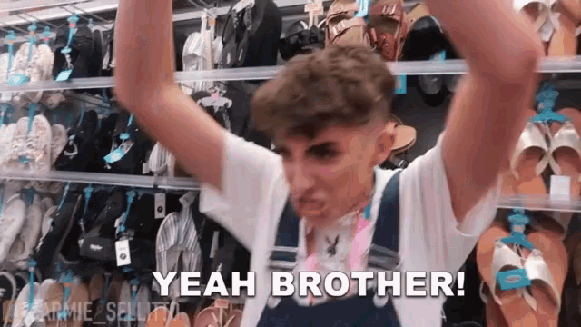 a young man is standing in front of a shelf of shoes and says yeah brother .