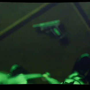 a man in a suit is holding a gun to his head