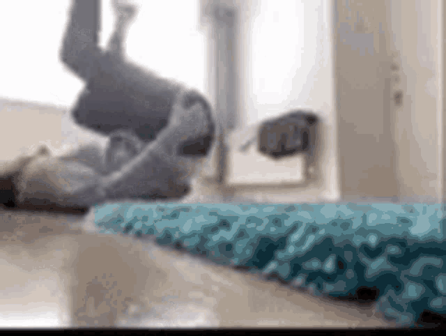 a woman is laying on her back on a blue rug .
