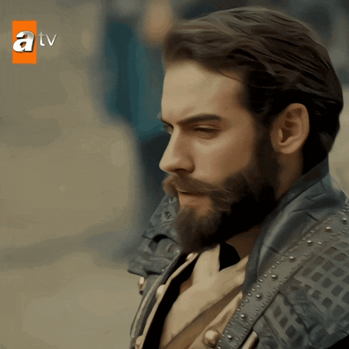 a man with a beard and mustache is featured on a tv screen