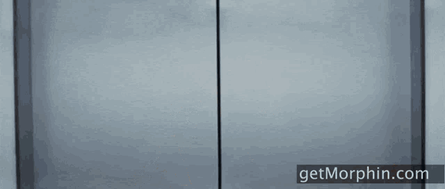 a woman wearing sunglasses is standing in a doorway with the website getmorphin.com in the corner