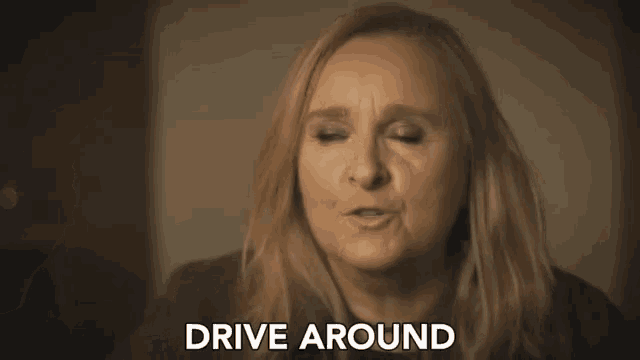 a woman in a dark room with the words drive around above her