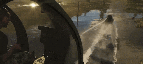 a man in a helicopter looks out the window at a boat going down a river