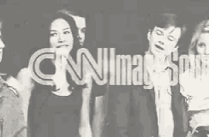 a group of people are standing next to each other and holding a sign that says cnn .