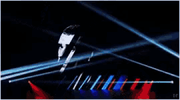 a man with a beard is surrounded by blue and red lights on a stage
