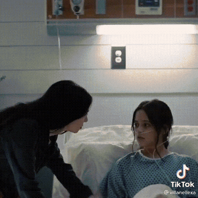 a woman is talking to a young girl in a hospital bed .