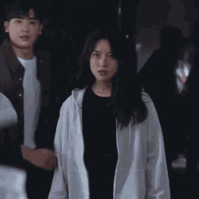 a man and woman are standing next to each other in a dark room .
