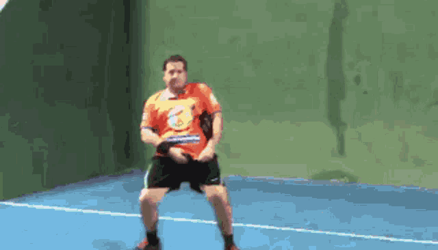 a man wearing an orange shirt with the letter e on it