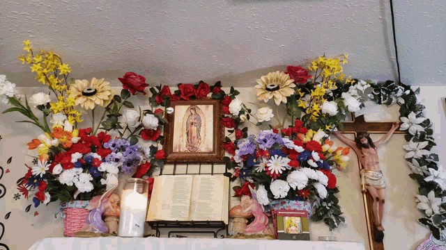 a religious altar with flowers and a bible