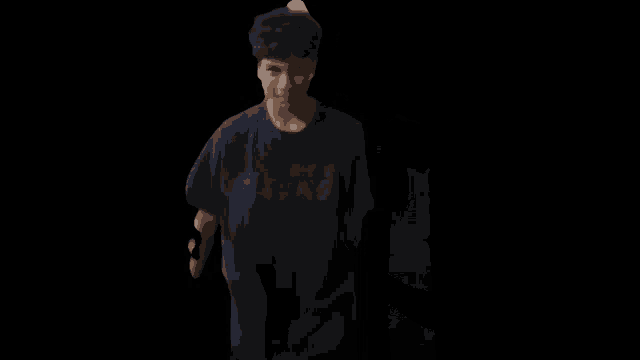 a man in a black shirt is standing in front of a refrigerator and dancing .