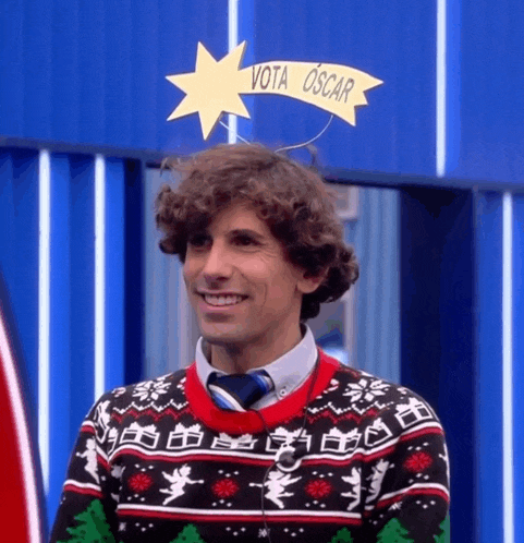 a man wearing a christmas sweater and tie has a star on his head that says vota oscar