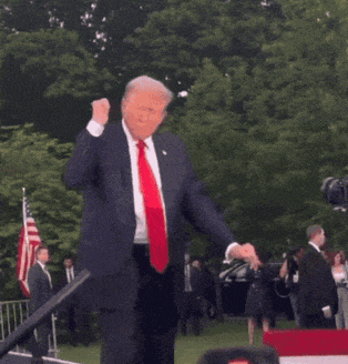 a man in a suit and tie is dancing in front of a crowd