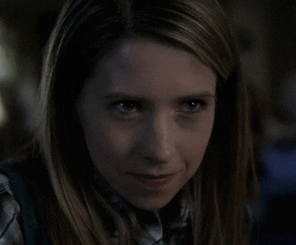 a woman in a plaid shirt is looking at the camera