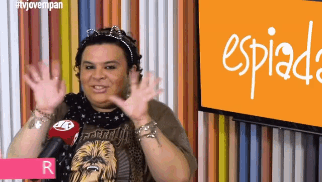 a woman wearing a chewbacca shirt is waving her hands