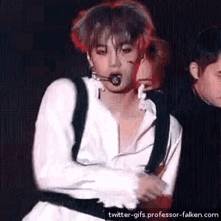 a man in a white shirt is dancing on a stage .