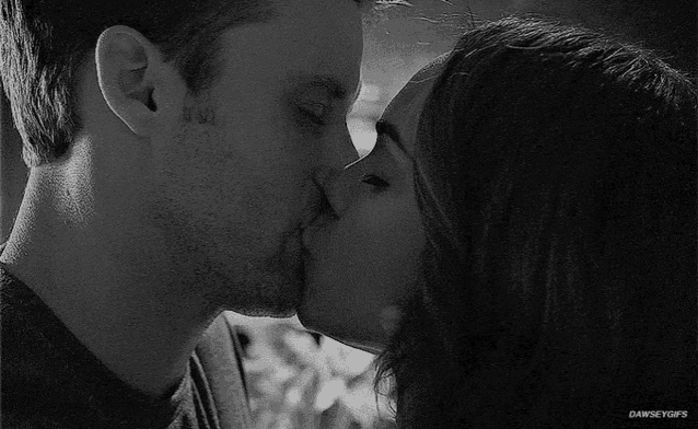 a black and white photo of a man and a woman kissing with the caption danseygifs