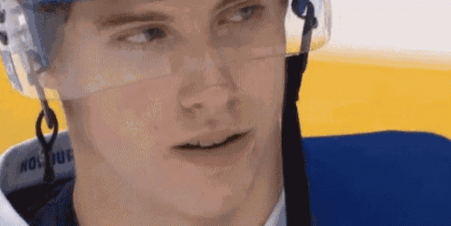 a close up of a hockey player 's face wearing a helmet and goggles .
