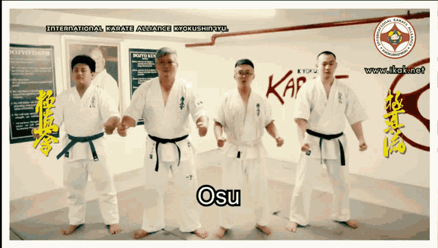 four men in karate uniforms stand in front of a wall that says international karate alliance kyokushinkyu