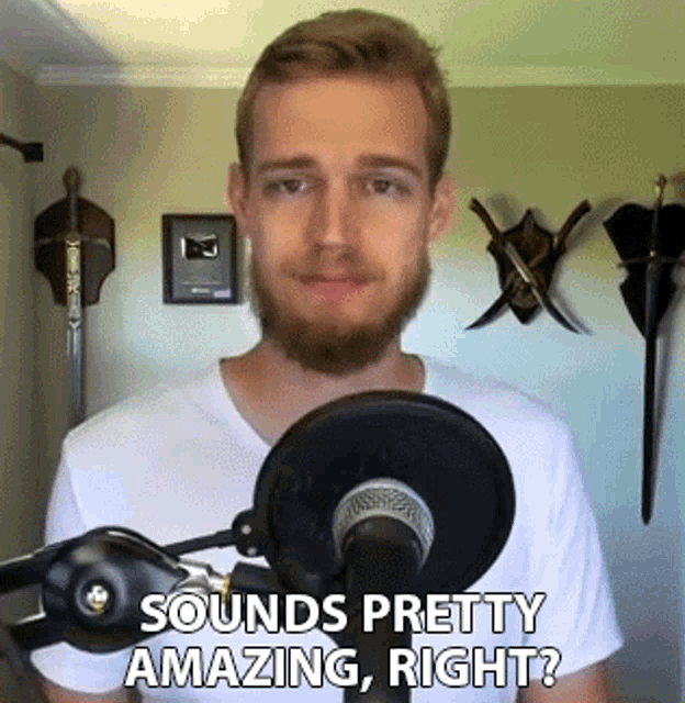 a man with a beard stands in front of a microphone and says sounds pretty amazing right ?