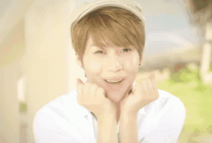 a young man wearing a hat and a white shirt is smiling and making a funny face .