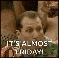 a man is sitting at a table with a drink in his hand and says `` it 's almost friday '' .