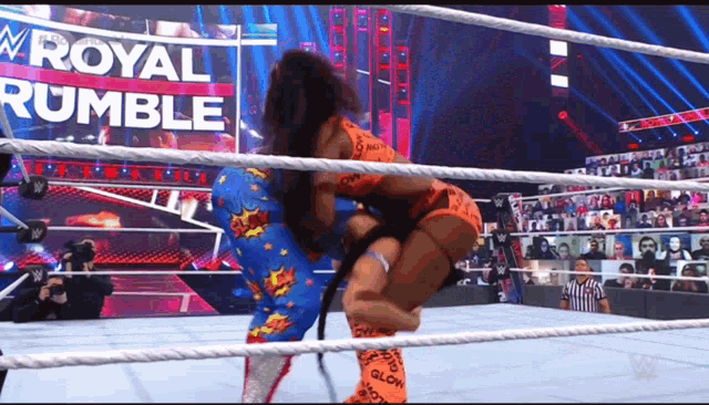 two women are wrestling in a wrestling ring with the words royal rumble behind them