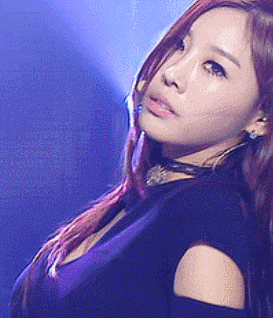 a woman with red hair is wearing a black top