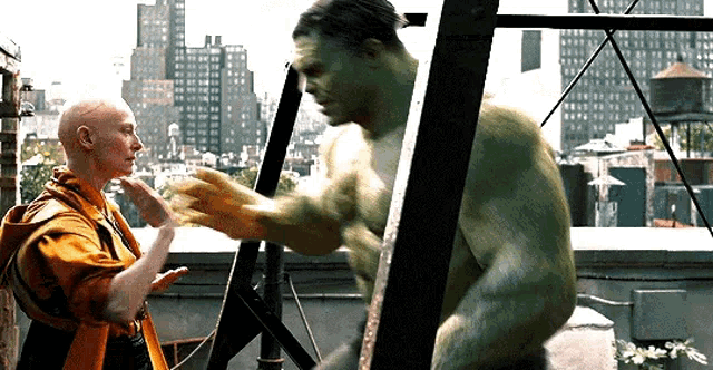 hulk and doctor strange are standing next to each other on a roof .