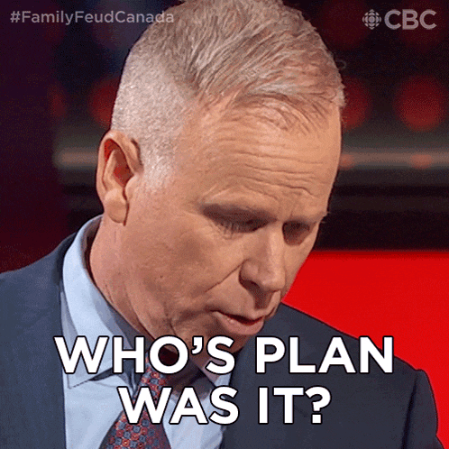 a man says who 's plan was it while wearing a suit and tie