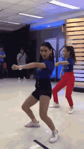 two girls are dancing in a dance studio .