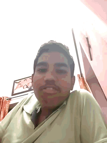 a man in a green shirt is smiling in front of a picture