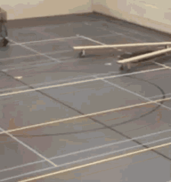 a man is walking in a gym while another man pushes a wheelbarrow .