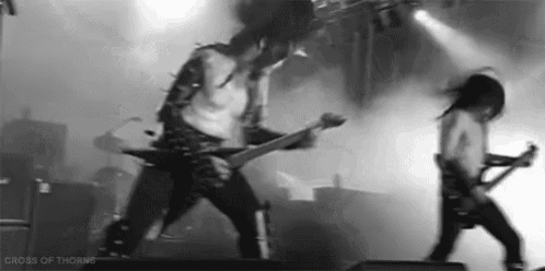 a couple of men are playing guitars on a stage in a black and white photo .