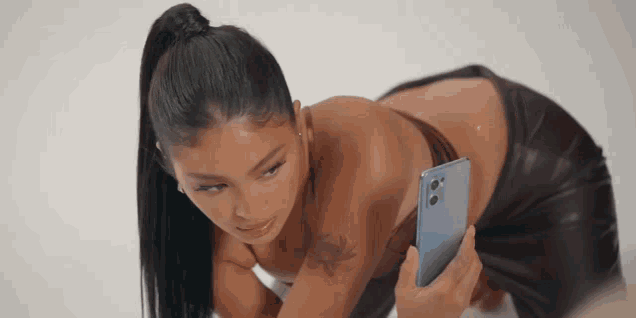 a woman in a bikini is taking a picture of herself with her phone .