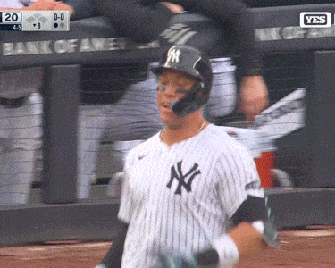 a new york yankees baseball player stands in front of a bank of america dugout