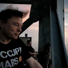 a man wearing a black shirt that says occupy mars on it