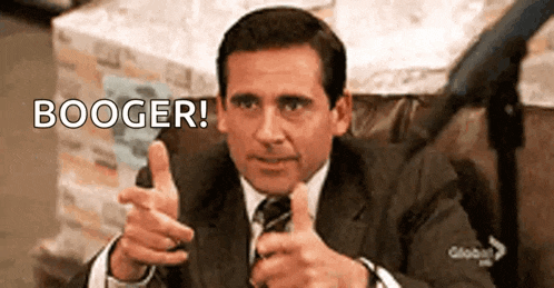 a man in a suit and tie is giving a thumbs up and pointing .