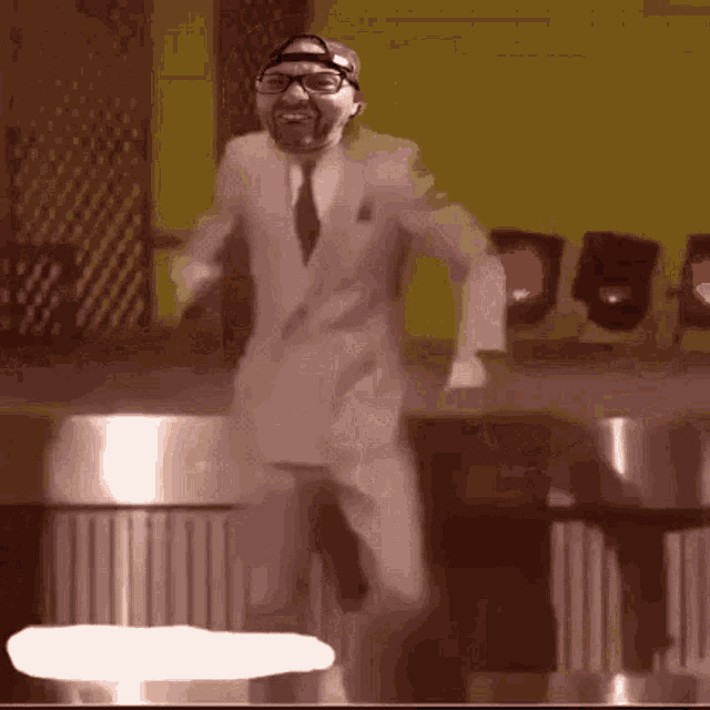 a man in a suit and tie is dancing in front of a trash can