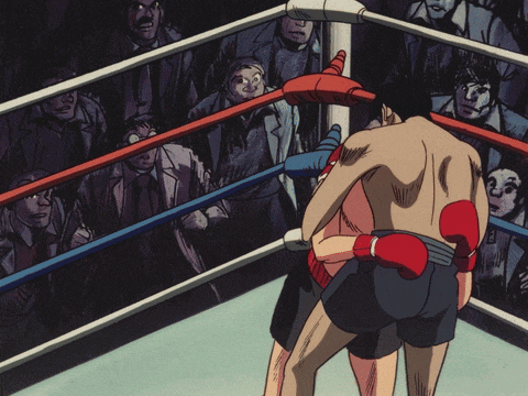 two boxers are fighting in a ring with a crowd in the background