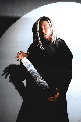 a man with dreadlocks is holding a stack of cards