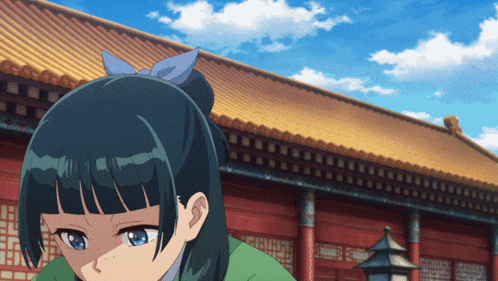 a girl with a blue bow in her hair stands in front of a red building