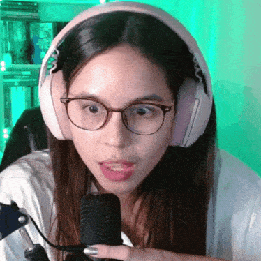 a woman wearing glasses and headphones looks surprised