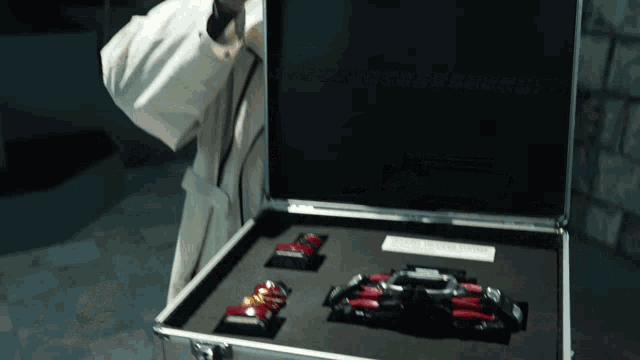 a man in a white coat is holding a briefcase with a few cars inside of it
