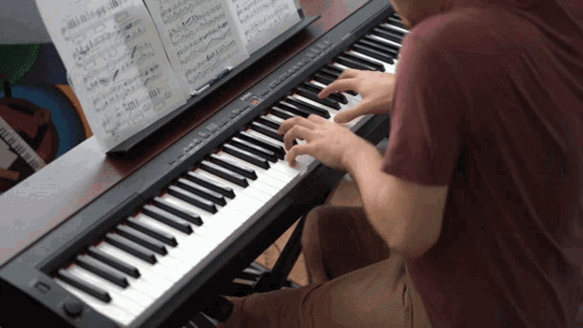 a man is playing a piano with a sheet of music behind him