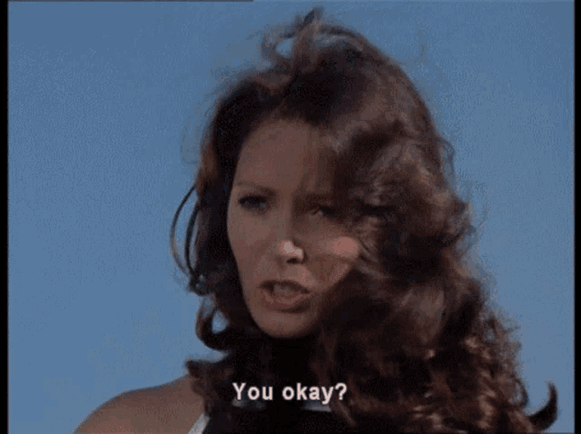 a woman wearing a helmet is sitting in a car and says " you okay "