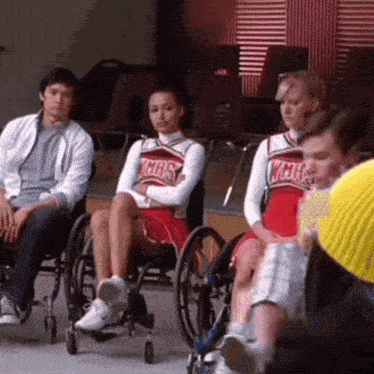 a girl in a wmhs uniform sits in a wheelchair