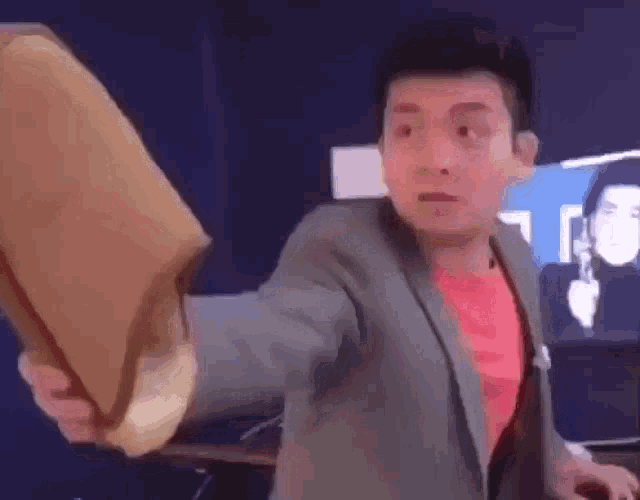 a man in a suit is holding a large piece of paper in his hands .
