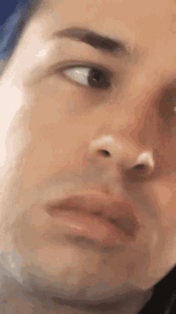 a close up of a man 's face with a white spot on his nose .