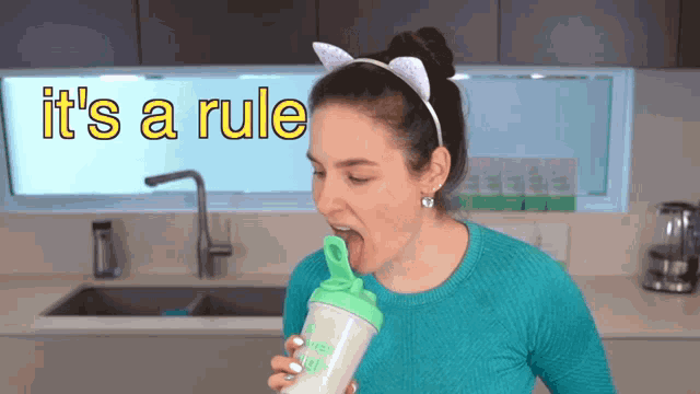 a woman drinking from a shaker that says it 's a rule on it