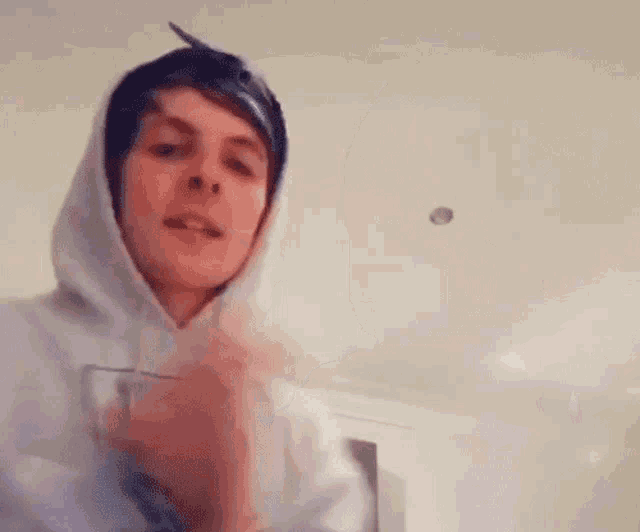 a blurry picture of a man wearing a hooded jacket and a bandana .